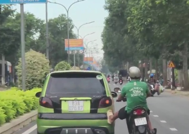 Xe gắn máy đẩy xe ô tô trên đường phố Sóc Trăng - Ảnh 1.