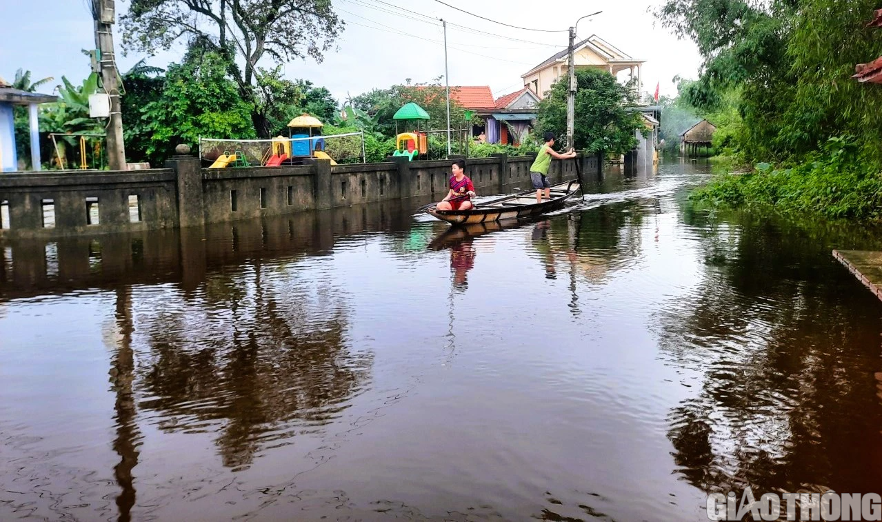 Nhiều nơi tại Quảng Trị và Huế ngập sâu, dân di chuyển bằng thuyền, bò lên cầu tránh lụt - Ảnh 1.