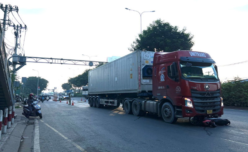 Nạn nhân và chiếc xe máy bị cuốn vào gầm xe container sau va chạm.