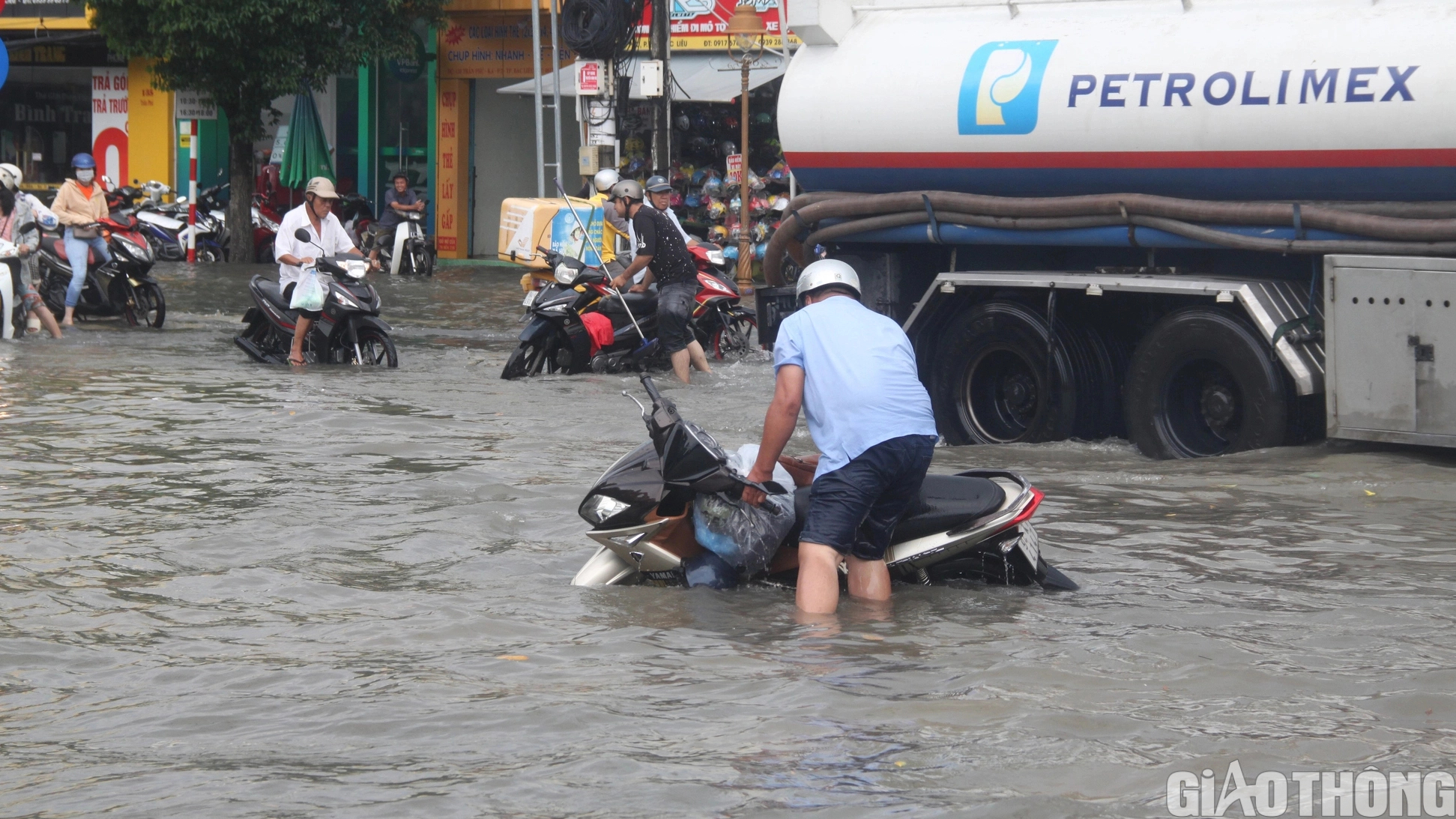 Người dân Bạc Liêu bì bõm dẫn xe lội nước sau cơn mưa lớn kéo dài - Ảnh 3.