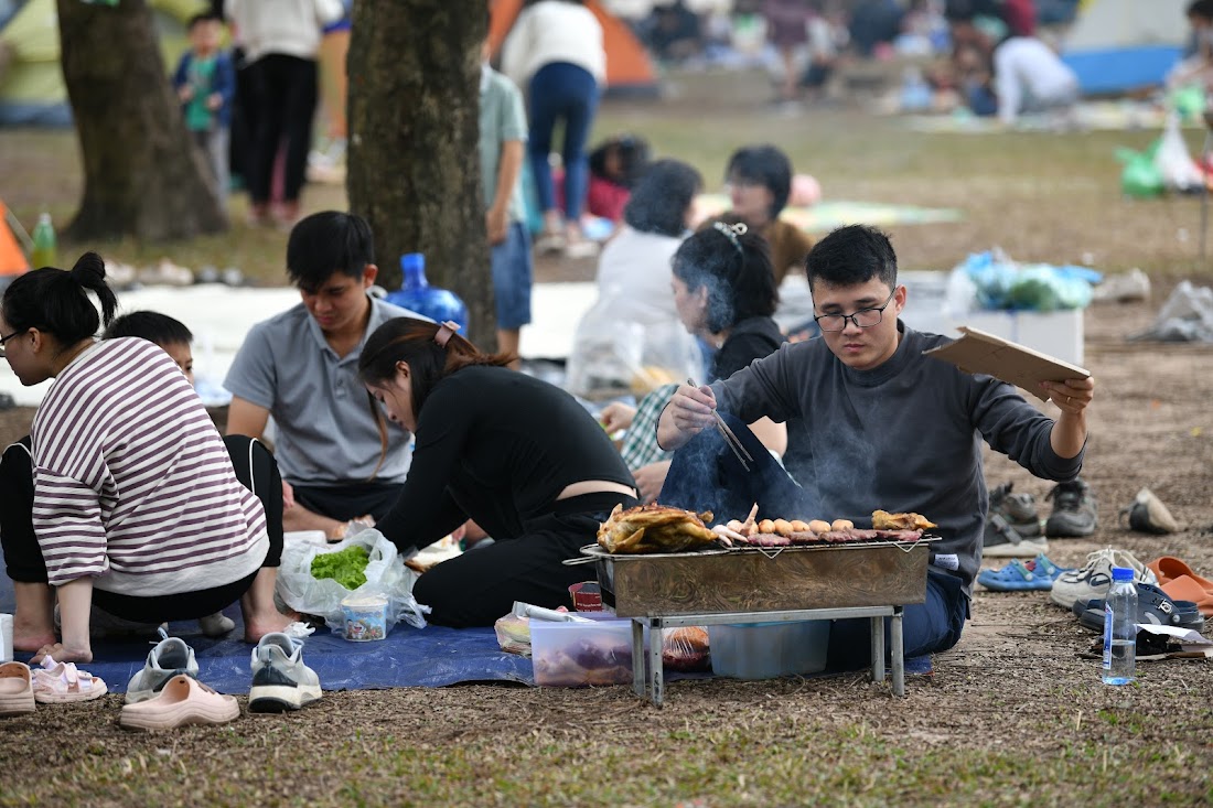 Người dân dựng lều, trải bạt, đổ xô về các công viên ở Hà Nội dịp nghỉ tết - Ảnh 13.