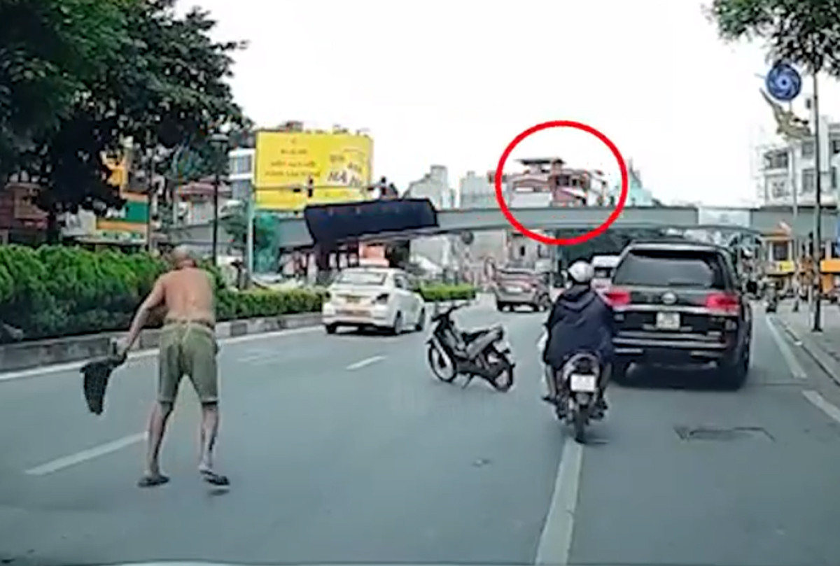 Người đàn ông đi xe máy phi dao thủng kính ô tô ở Hà Nội - Ảnh 1.