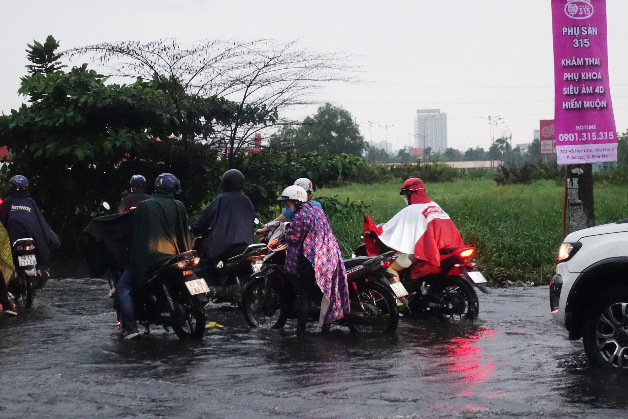 Nhiều tuyến đường tại TP.HCM ngập sâu sau trận mưa,  khiến người dân bì bõm dắt xe giữa dòng nước - Ảnh 2.