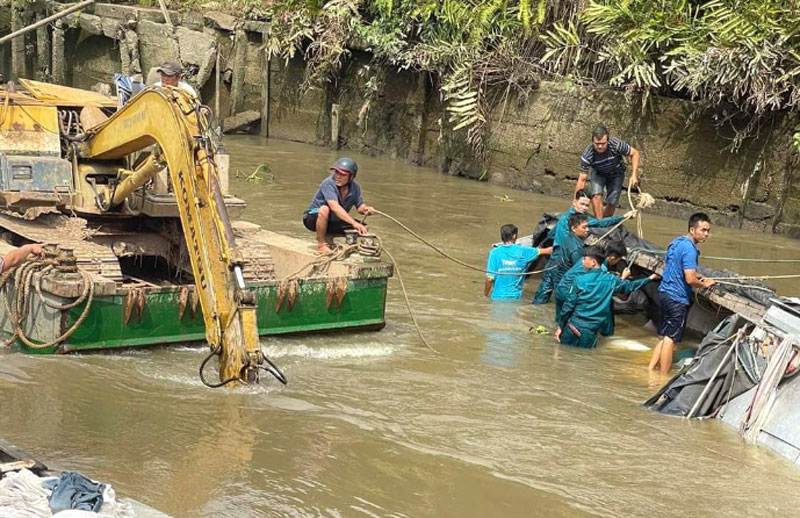 Ngành chức năng cùng người dân hỗ trợ trục vớt phương tiện và số gạo bị chìm lên bờ.