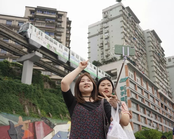 Đứng chiêm ngưỡng đoàn tàu đi xuyên qua tòa nhà cao tầng là trải nghiệm nhiều du khách không thể bỏ lỡ khi đến Trùng Khánh. (Ảnh: iChongqing)