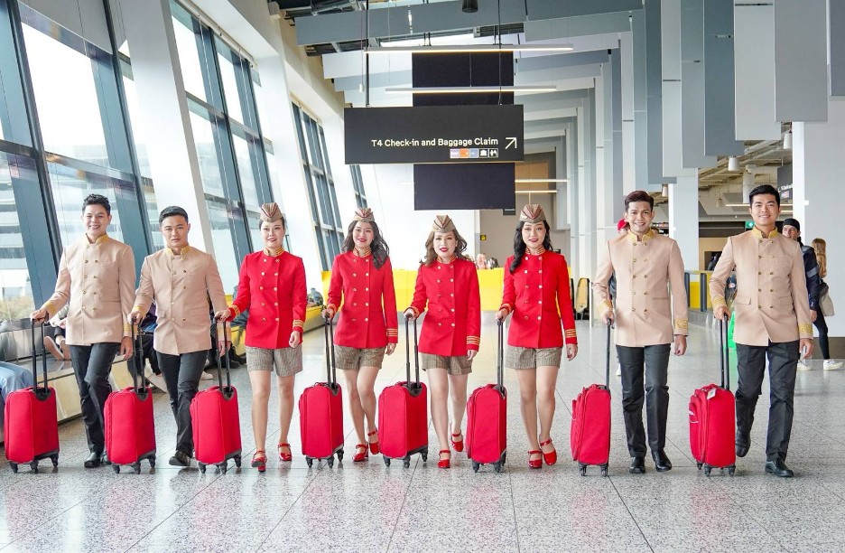 A group of people in uniform with luggage  Description automatically generated