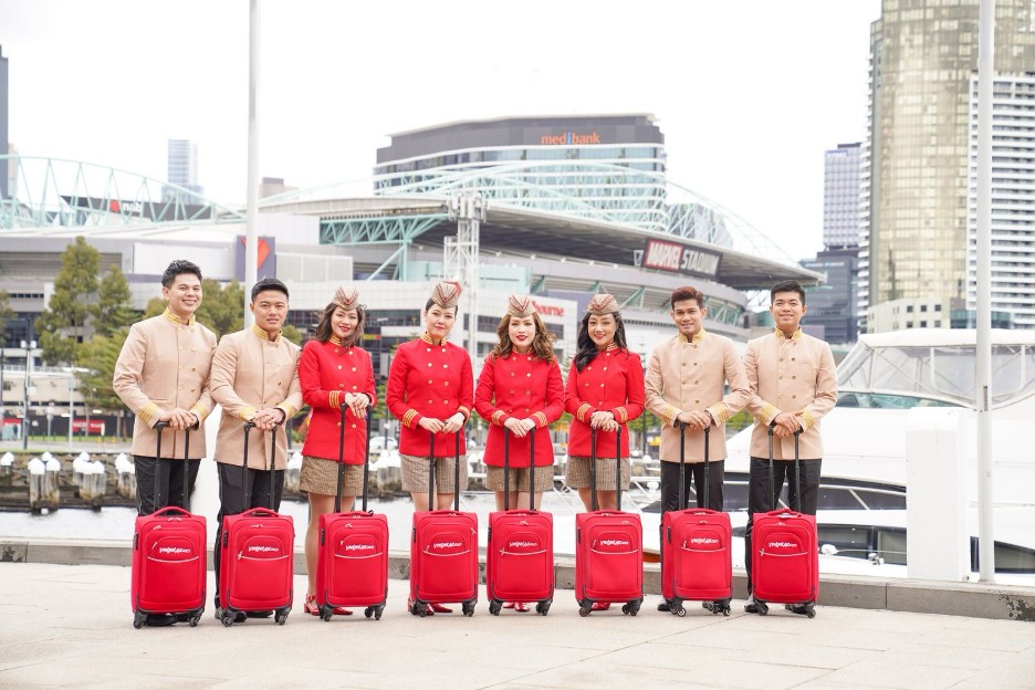 A group of people standing in front of luggage  Description automatically generated