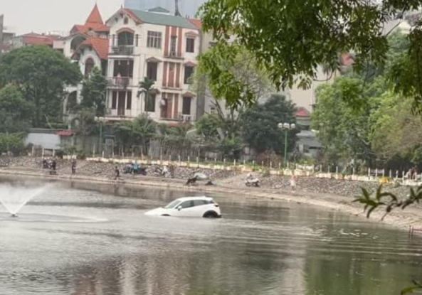 Clip: Hàng chục người giải cứu ô tô lao xuống hồ nước ở Hà Nội- Ảnh 1.