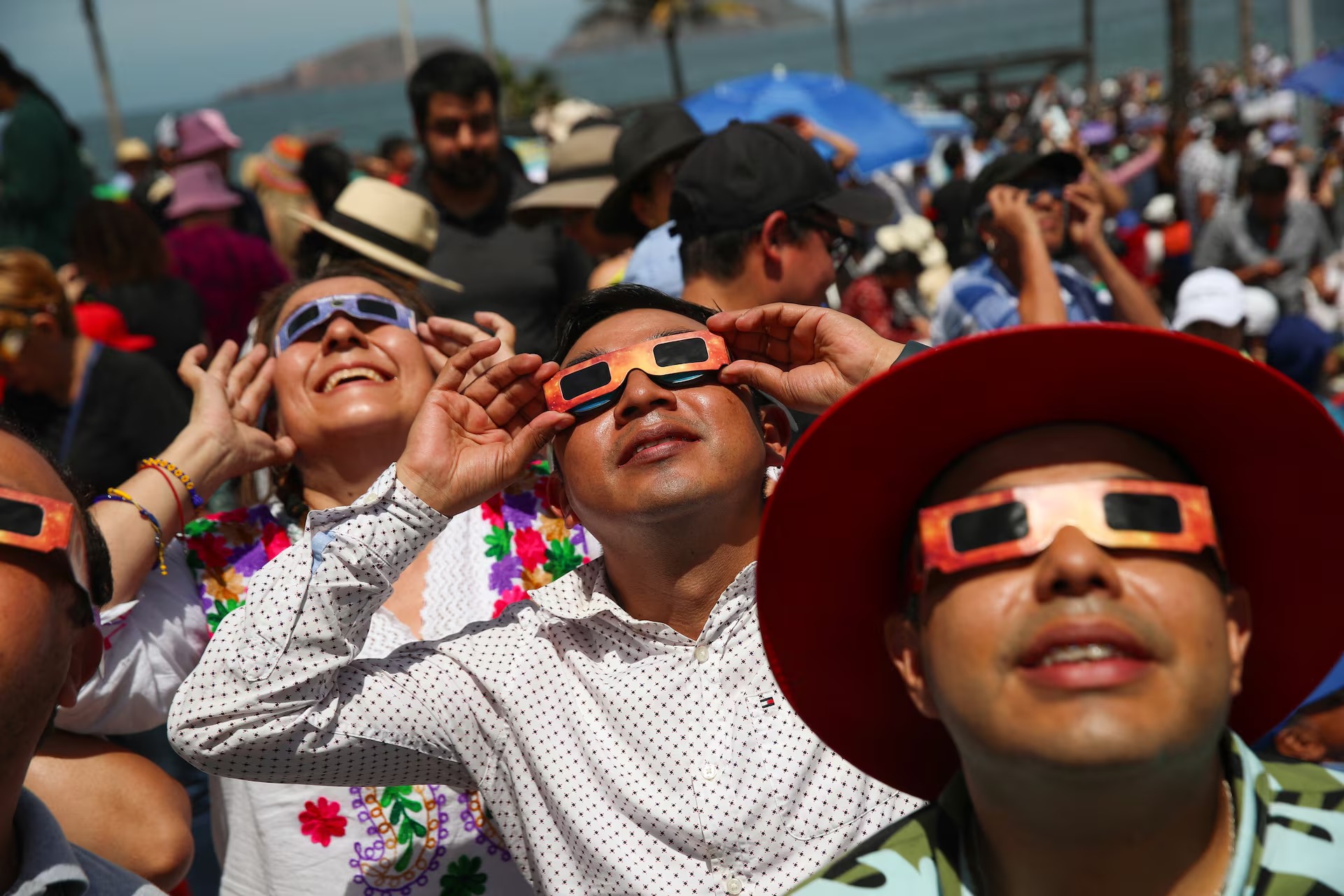 Người dân sử dụng kính bảo vệ đặc biệt để quan sát nhật thực toàn phần ở Mazatlan, Mexico. Khi chiêm ngưỡng nhật thực, người xem bắt buộc phải đeo kính để phòng tránh các tia cực tím gây ra những vấn đề nghiêm trọng với mắt, thậm chí gây mù loà. (Ảnh: Reuters)