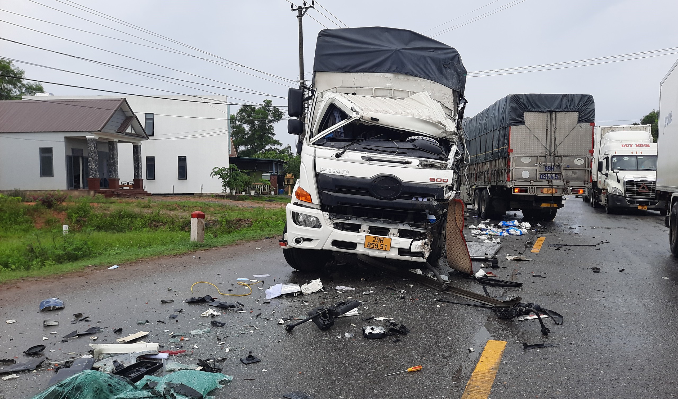 Hai xe tải bẹp dúm đầu sau cú tông trực diện, tài xế bị thương nặng- Ảnh 1.