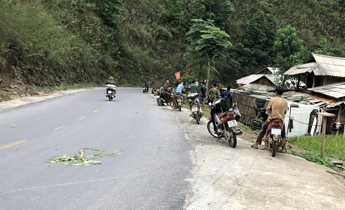 Tại hiện trường, chiếc xe khách bị lật ngang xuống ven đường khiến 2 người bị thương - Ảnh: Trấn Long.