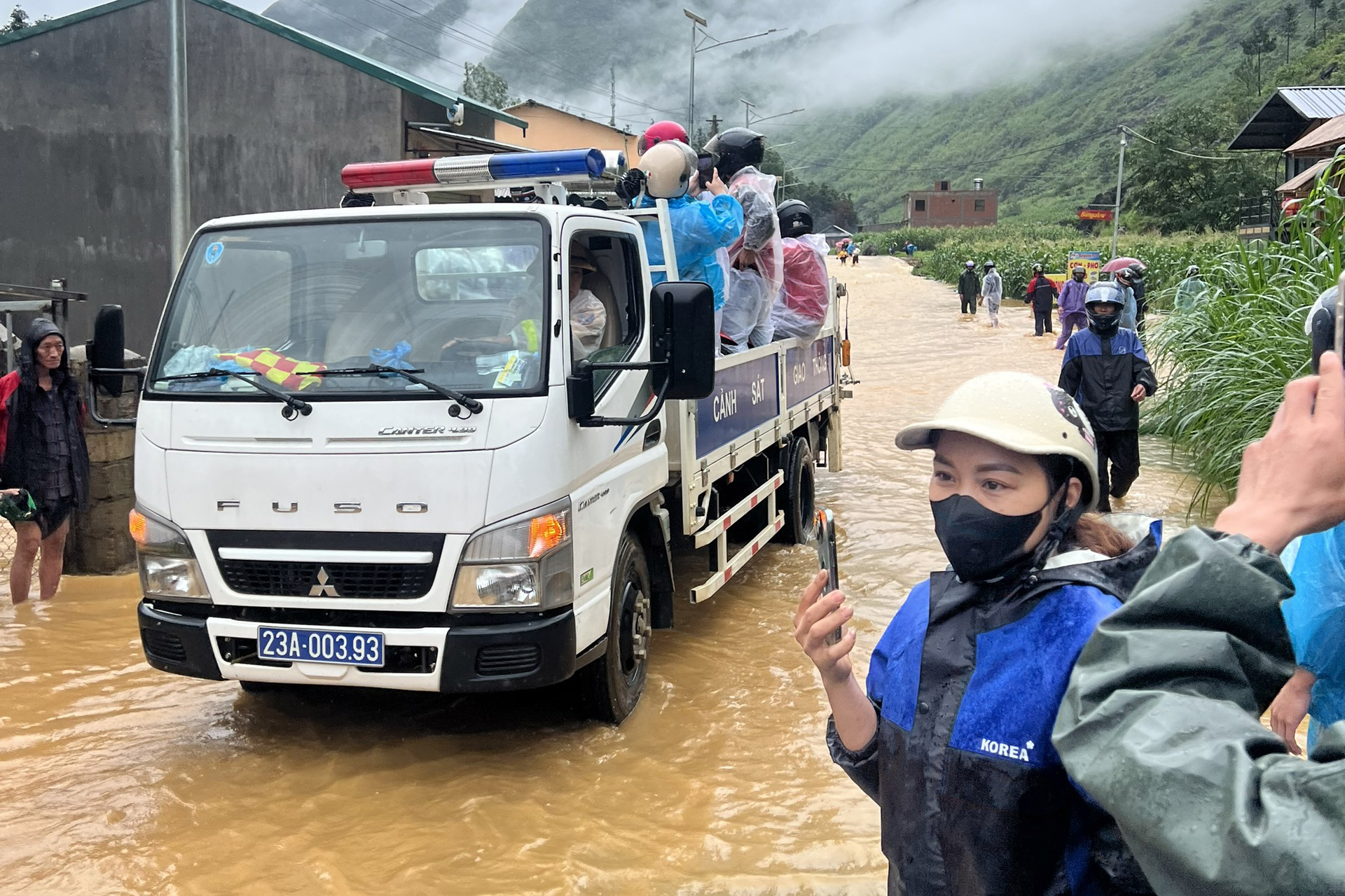 CSGT dùng xe chuyên dụng chở khách Tây, người dân bị kẹt trong lũ lụt- Ảnh 1.
