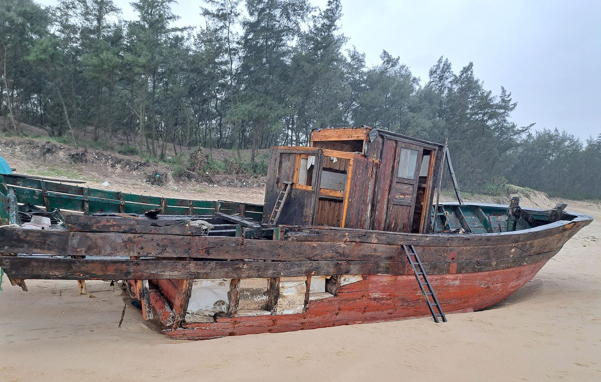 Tiêu hủy tàu gỗ vô chủ trôi dạt vào bờ biển Quảng Trị- Ảnh 1.