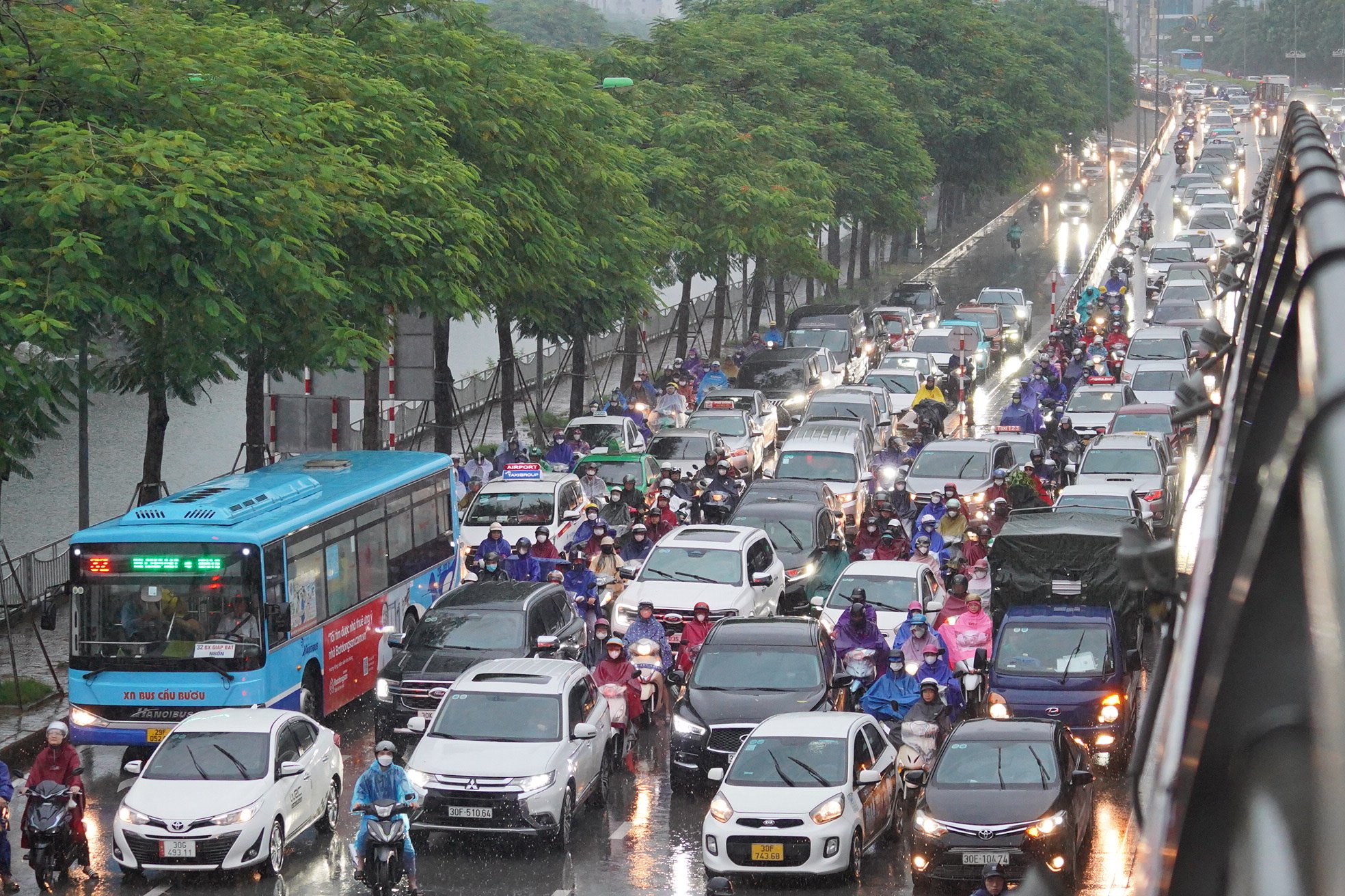 Mưa kéo dài, người dân Hà Nội chật vật di chuyển trên đường phố ùn tắc- Ảnh 9.