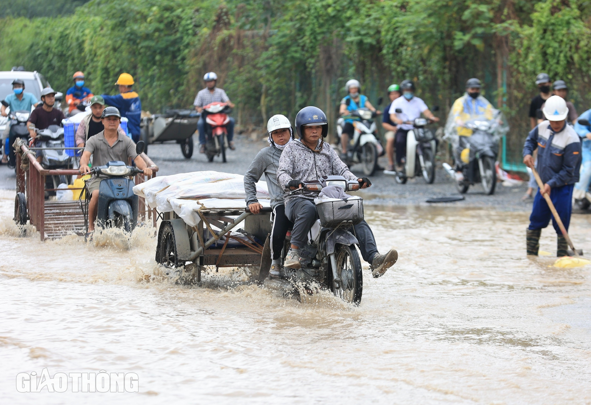 Đại lộ Thăng Long vẫn ngập sâu, người dân "bì bõm" đi làm- Ảnh 1.