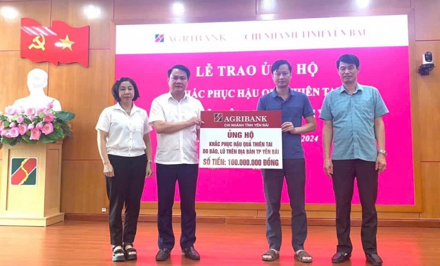 A group of people standing in front of a pink sign  Description automatically generated