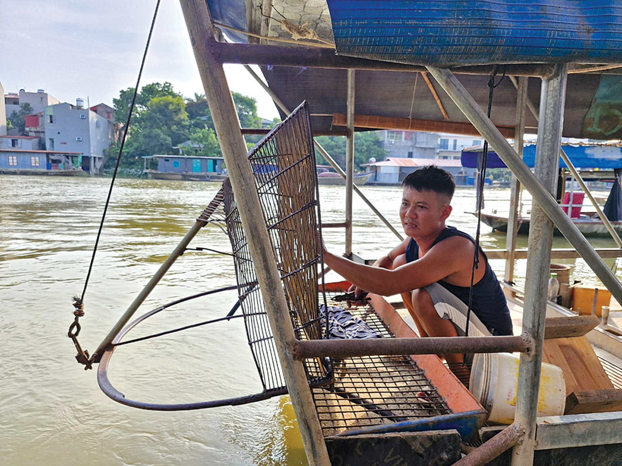 Anh Trần Văn Vững, thôn Nguyệt Đức chuẩn bị dung cụ cào để tối đến sẽ đi cào hến trên sông Cầu, đây là công việc cho thu nhập chính của gia đình 4 người trên sông