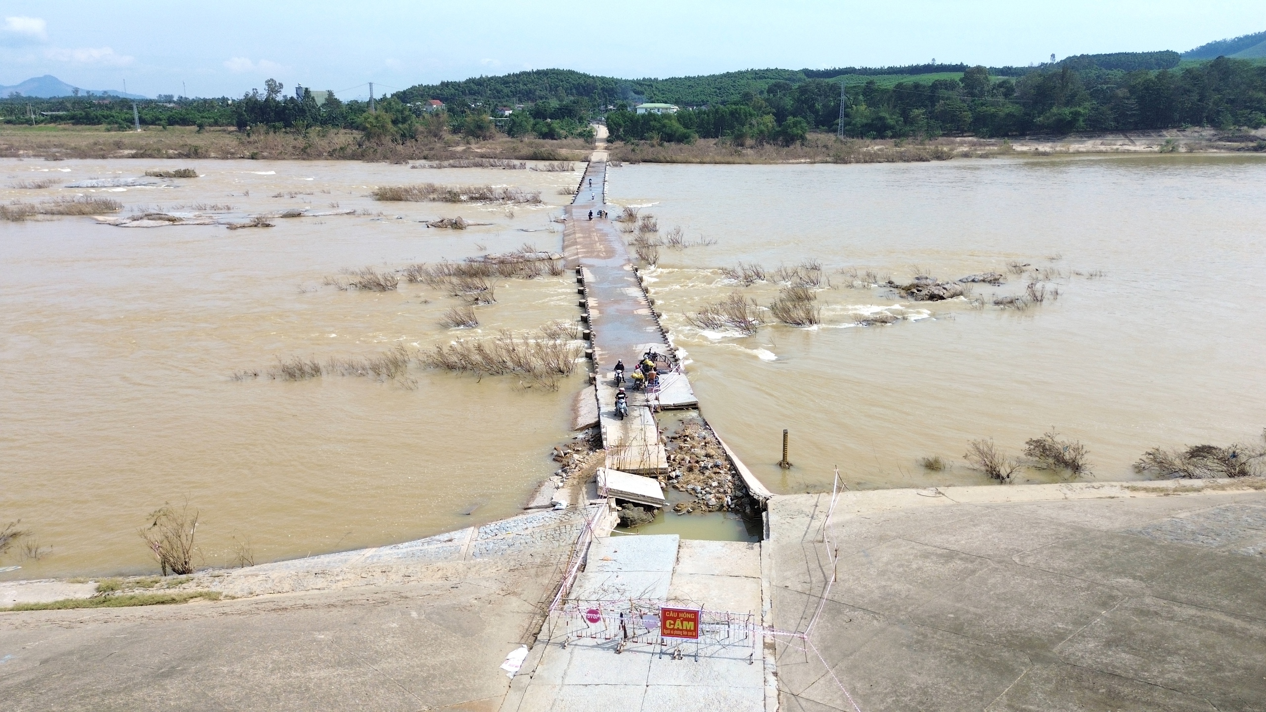 Quảng Ngãi: Người dân liều mình băng qua cầu tràn bị lũ cuốn trôi mặt bê tông- Ảnh 1.
