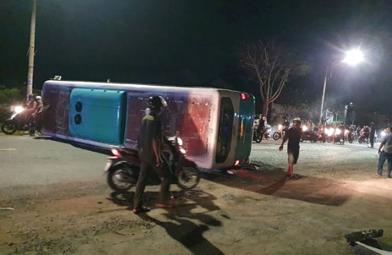 Chiếc xe chở công nhân lật ngang nằm giữa TL826 - Ảnh: DCG. Chiếc xe chở công nhân lật ngang nằm giữa TL826 - Ảnh: DCG.