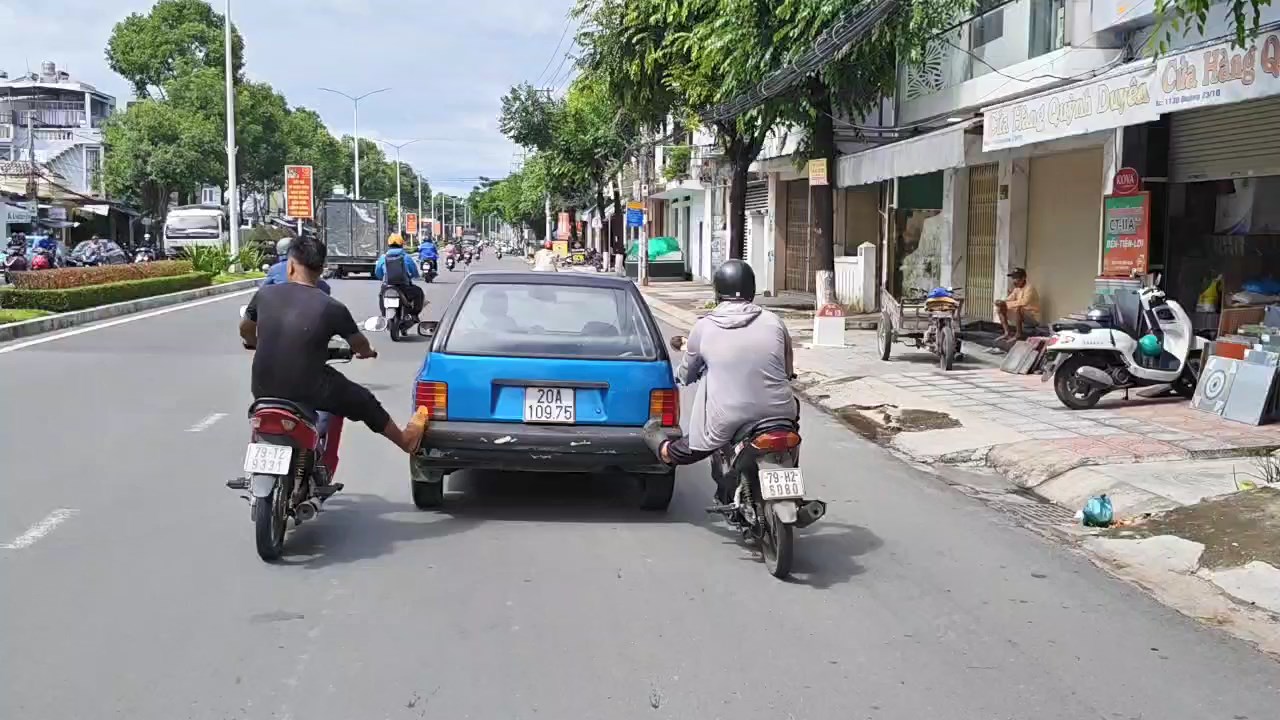 Xác minh vụ hai người đi xe máy dùng chân đẩy ô tô trên đường phố Nha Trang- Ảnh 1. Xác minh vụ hai người đi xe máy dùng chân đẩy ô tô trên đường phố Nha Trang- Ảnh 1.