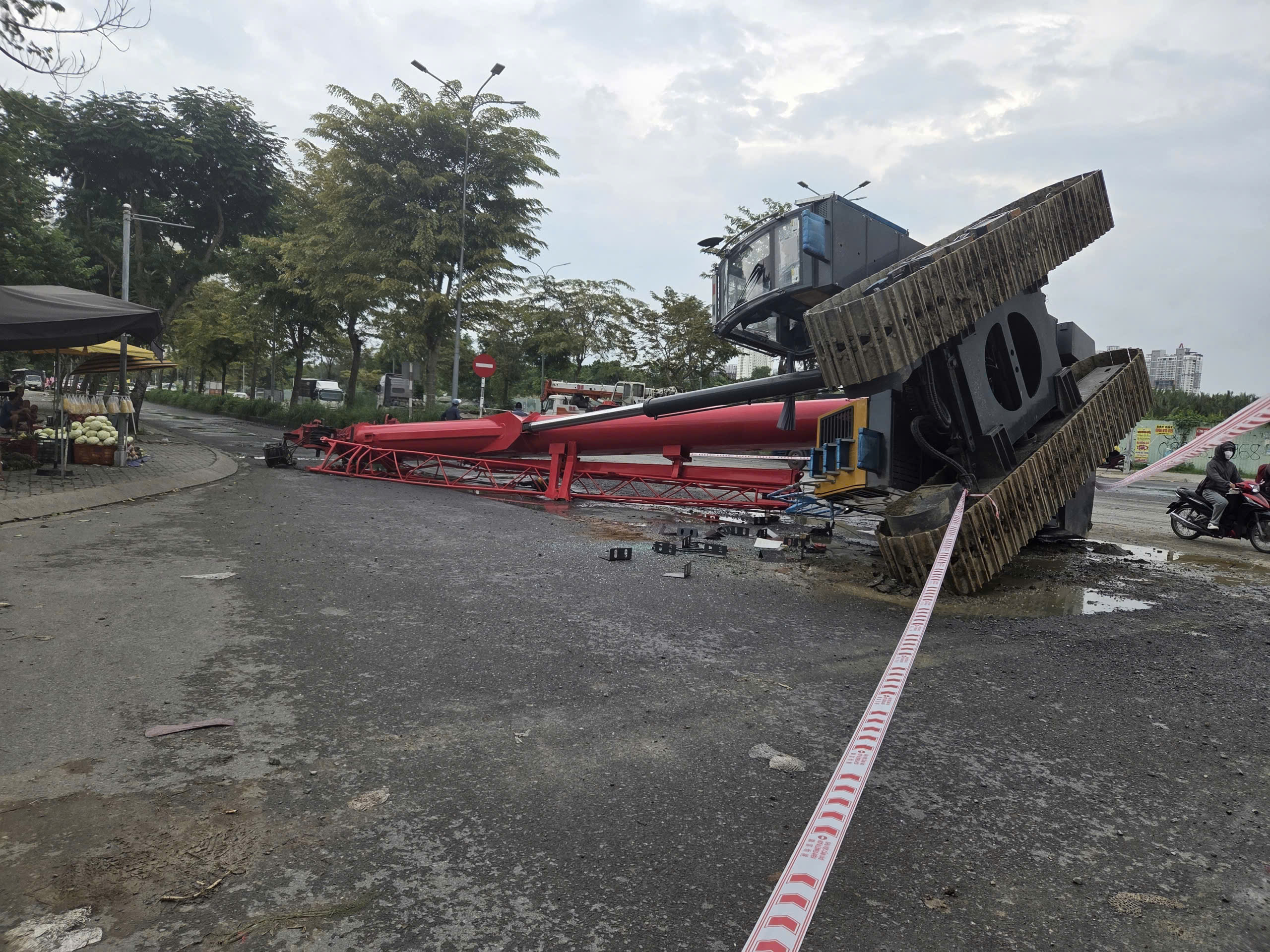 TP.HCM: Xe cẩu lật khỏi đầu kéo nằm chắn ngang đường, một người trọng thương- Ảnh 1. TP.HCM: Xe cẩu lật khỏi đầu kéo nằm chắn ngang đường, một người trọng thương- Ảnh 1.