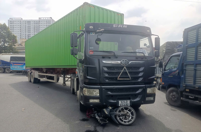 Nạn nhân và chiếc xe máy bị cuốn vào gầm xe container. Nạn nhân và chiếc xe máy bị cuốn vào gầm xe container.