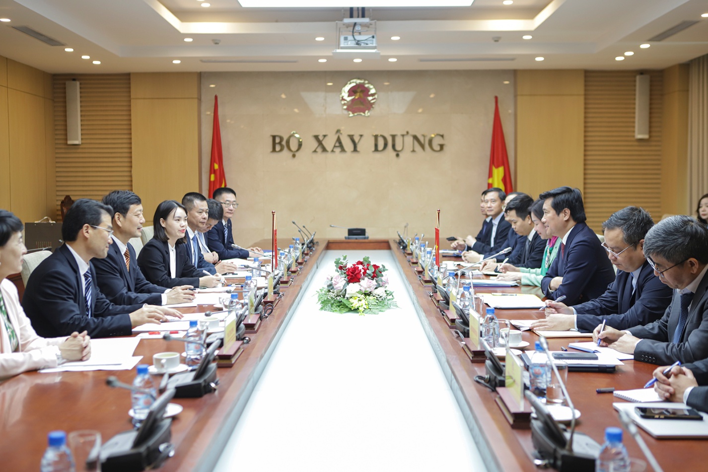 Vietnam, Guangxi deepen cooperation in housing planning and urban–rural development- Ảnh 1. A group of people sitting at a table AI-generated content may be incorrect.