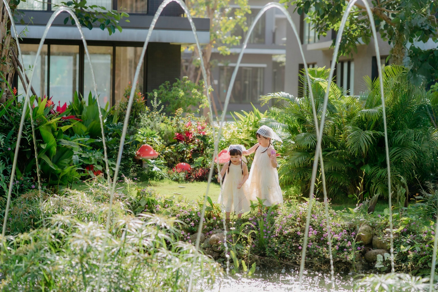 Giải phóng đôi chân, trải nghiệm mùa hè rực rỡ tại “Lễ hội mùa hè Eco Central Park 2025”- Ảnh 10. Two girls in white dresses playing in a garden Description automatically generated