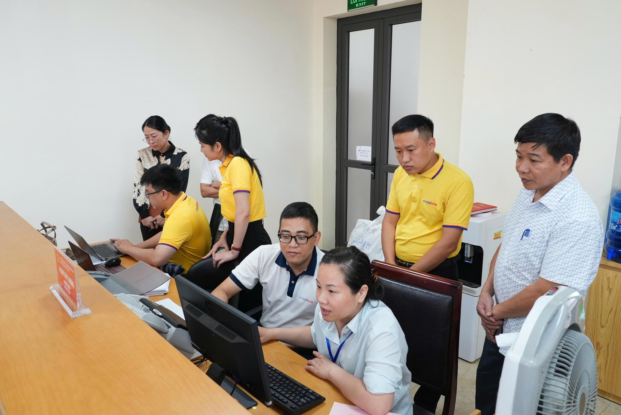 MobiFone - Tỉnh Thái Nguyên triển khai Hệ thống thông tin giải quyết thủ tục hành chính- Ảnh 1. A group of people in a room AI-generated content may be incorrect.