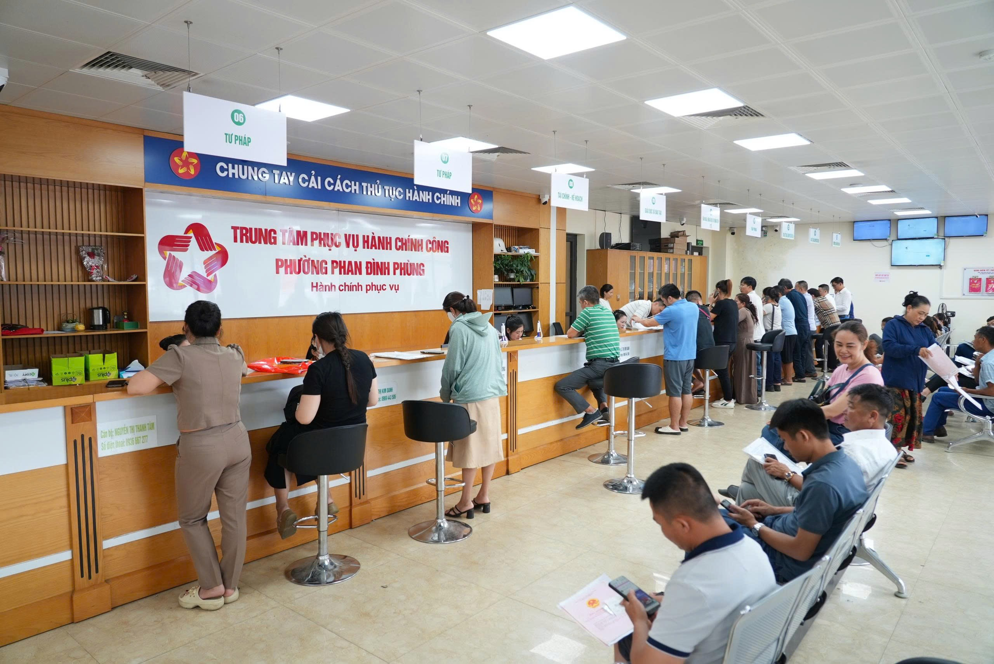 MobiFone - Tỉnh Thái Nguyên triển khai Hệ thống thông tin giải quyết thủ tục hành chính- Ảnh 2. People waiting in line at a counter AI-generated content may be incorrect.