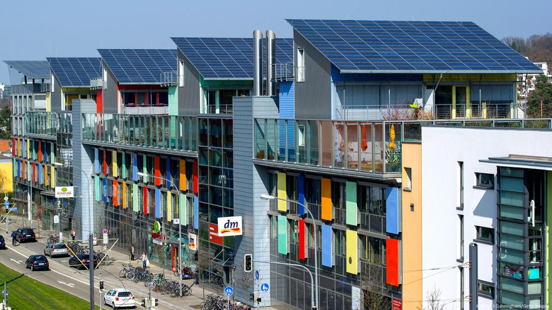 Cách phố cổ Freiburg, Đức giảm bớt ô tô cá nhân trong đô thị- Ảnh 3. A row of multi-story buildings with solar panels AI-generated content may be incorrect.