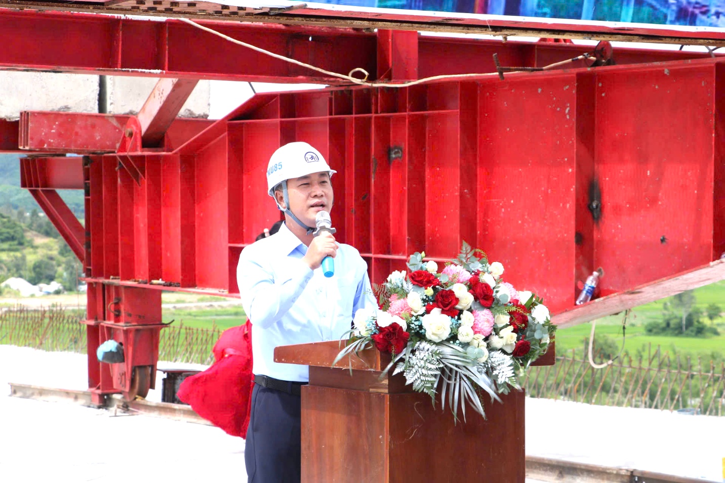 Deputy Minister Nguyen Viet Hung: Determined to complete Quy Nhon – Chi Thanh Expressway- Ảnh 1. A person wearing a helmet speaking into a microphone AI-generated content may be incorrect.