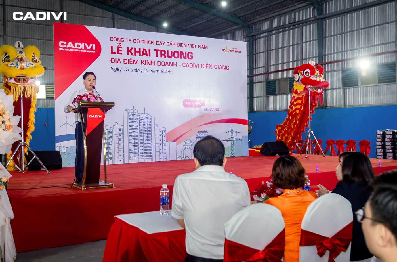 CADIVI Kiên Giang - Đẩy mạnh mở rộng mạng lưới phân phối khu vực Tây Nam Bộ- Ảnh 2. A person standing at a podium with a dragon on the stage AI-generated content may be incorrect.