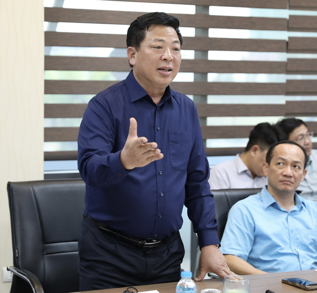 Minister Tran Hong Minh urges land clearance to ensure railway project stays on schedule- Ảnh 2. A person standing in front of a table with other people in the background AI-generated content may be incorrect.