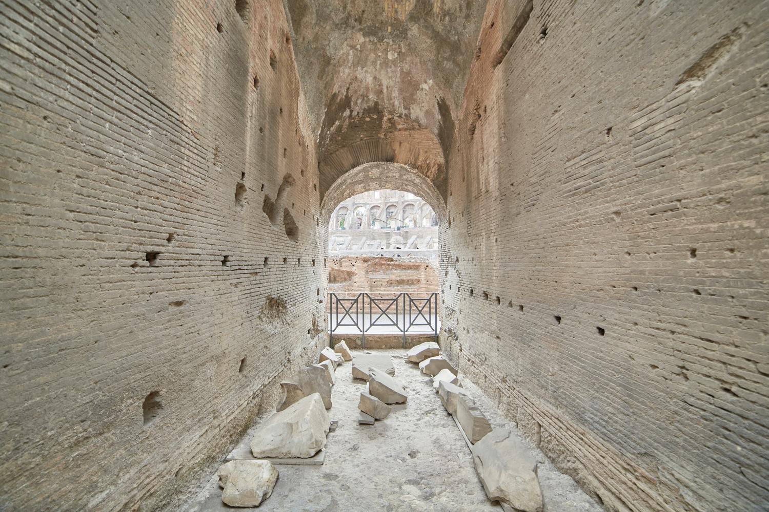 Hé lộ những kỹ thuật độc lạ trong bê tông thời La Mã- Ảnh 2. A stone tunnel with a gate AI-generated content may be incorrect.