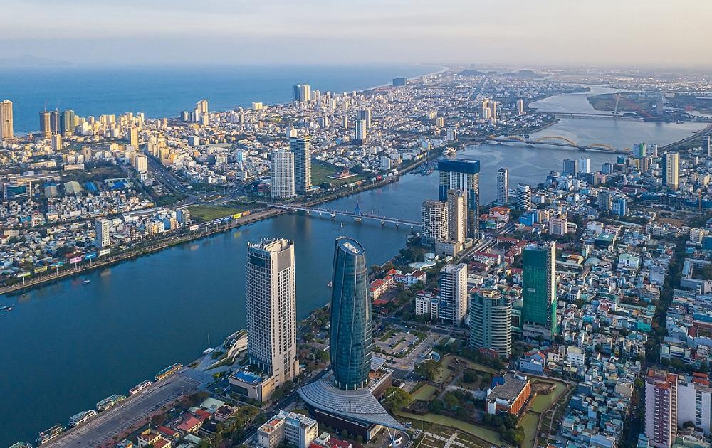 Giải mã sức hút đến từ căn hộ trung tâm Đà Nẵng- Ảnh 1. A city with a body of water AI-generated content may be incorrect.