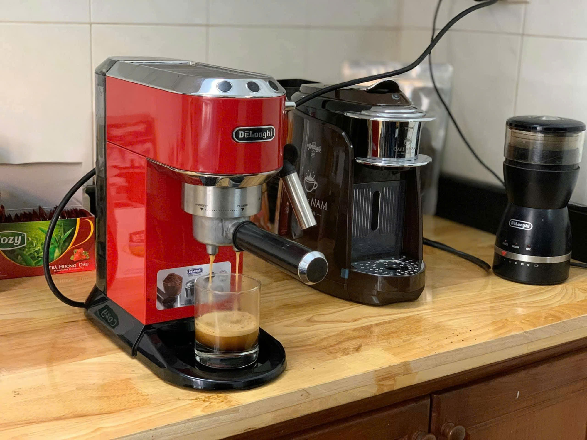 Sắm máy pha cà phê mini, nâng tầm trải nghiệm tại gia- Ảnh 1. A red and black machine on a counter Description automatically generated