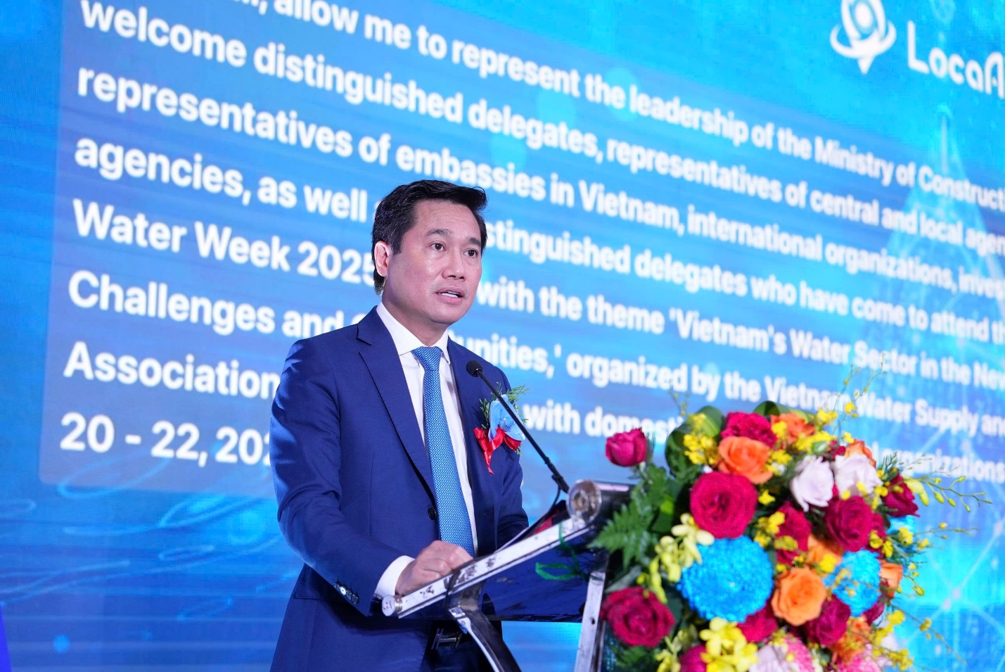 Ensure universal access to safe, high-quality water, says Deputy Minister Nguyen Tuong Van- Ảnh 1. A person standing at a podium with flowers AI-generated content may be incorrect.