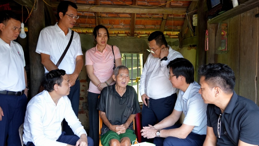 Petrovietnam chung tay hỗ trợ khắc phục hậu quả bão số 5- Ảnh 1. A group of people standing around a person sitting in a chair AI-generated content may be incorrect.