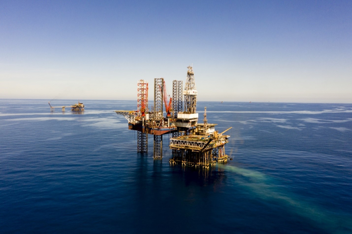 Hệ sinh thái Petrovietnam: Kiến tạo năng lực cốt lõi cho tăng trưởng xanh, bền vững- Ảnh 2. An oil rig in the ocean AI-generated content may be incorrect.