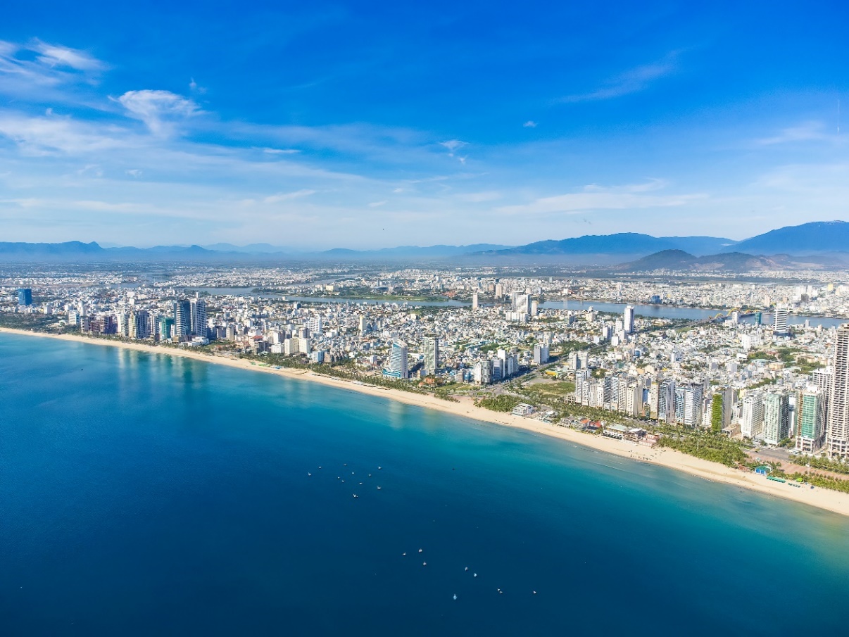 Kỳ vọng và tiềm lực đòn bẩy bất động sản Đà Nẵng- Ảnh 1. A city next to a body of water AI-generated content may be incorrect.