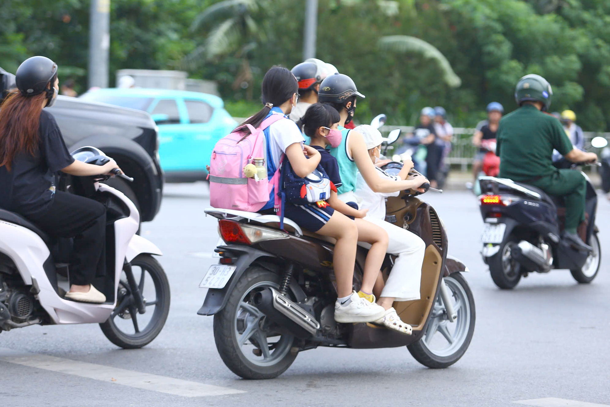 Hà Nội: CSGT xử lý nhiều phụ huynh chở 3, kẹp 4 đưa con đến trường- Ảnh 2.