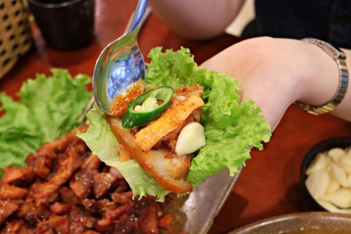 Món chân giò Hàn Quốc được ăn kèm rau và nước sốt