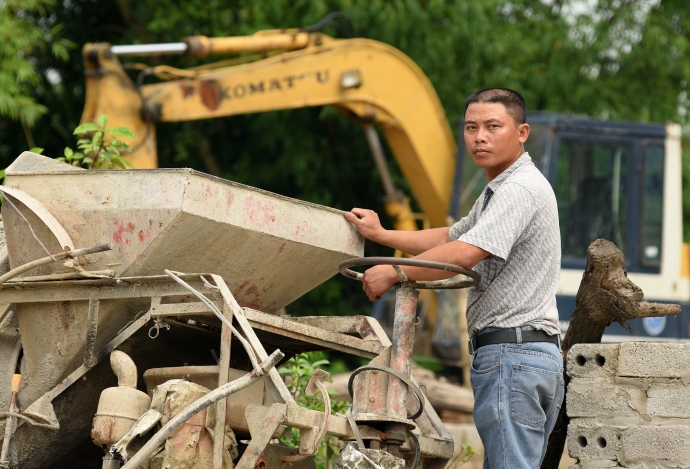 Anh Hậu bên chiếc máy trộn bê tông mà đơn vị thi c