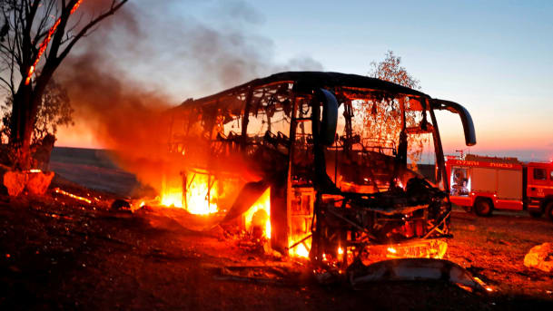 Một chiếc xe buýt bốc cháy sau khi trúng tên lửa b
