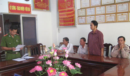 Bị can Nguyễn Hữu Minh (đứng) cùng các bị can khác nghe cơ quan CSĐT công bố quyết định khởi tố 