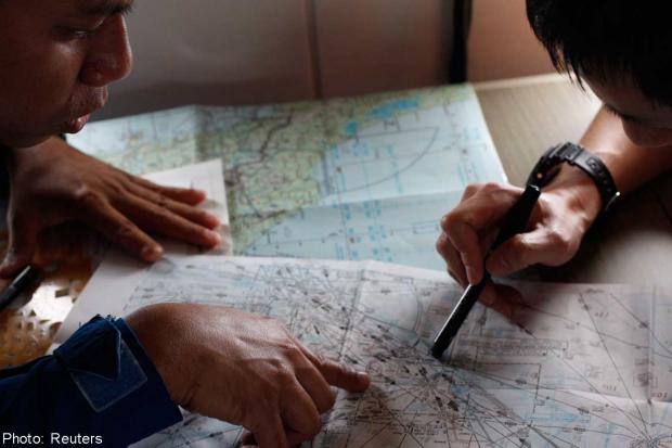 Đội bảo vệ bờ biển Nhật Bản đang xem bản đồ tìm kiếm cùng phi công của Cơ quan thực thi luật biển Malaysia 