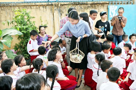 Hoa hậu Trương Thị May hướng dẫn các em học sinh gấp hộp sữa và thu hồi để làm tấm lợp sinh thái