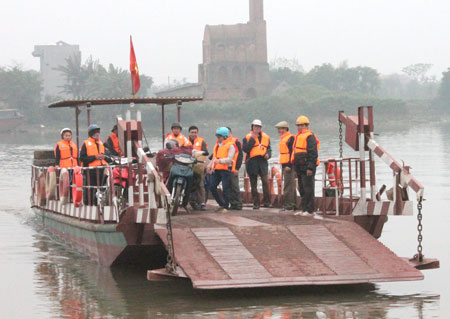 Người đi đò nghiêm túc mặc áo phao tại Bến đò Huyện (xã Hải Minh, huyện Hải Hậu, Nam Định)