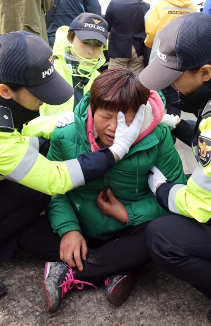 Một cảnh sát lau nước mắt động viên mẹ nạn nhân
